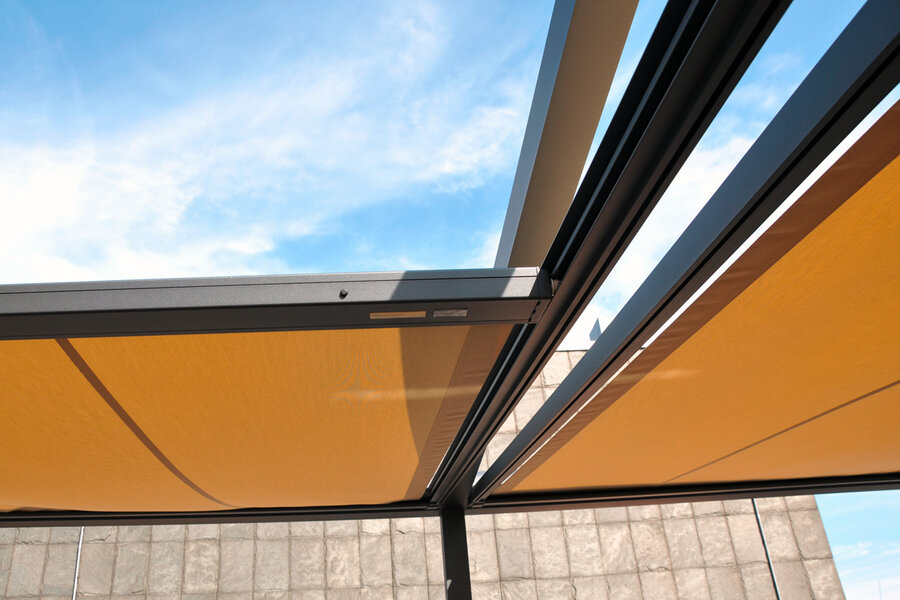 Q.Bus System mit antrazitfarbendem Metallgestell und verfahrbaren Stofftüchern in beigebraun auf einer Dachterrasse
