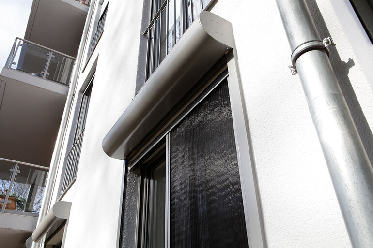 Individuell angefertigte Insektenschutzrahmen  in grau mit Schienenführung an einem bodentiefen Fenster.