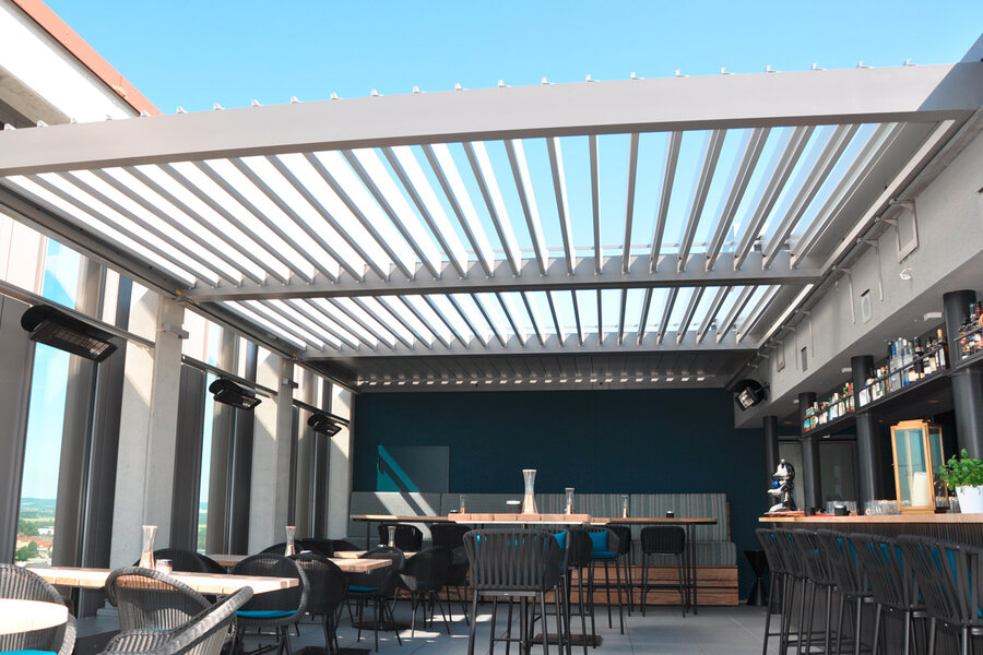Ansichten des Lamellendach Camarque mit verstellbaren Lamellen in Aluminium über der Dachterrasse eines Restaurants