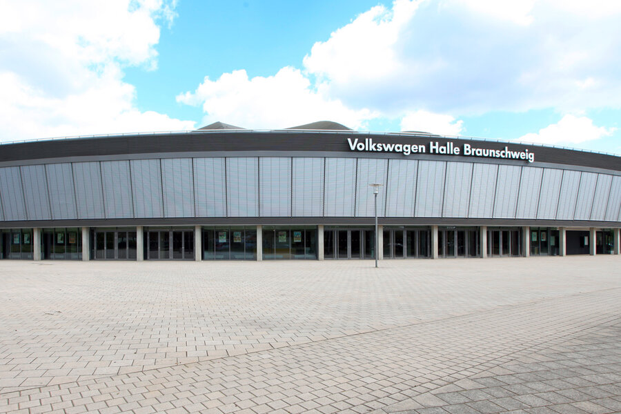 Blick auf die Außenfront einer großen Veranstaltungshalle mit heruntergelassenen Außenjalousien im Obergeschoß