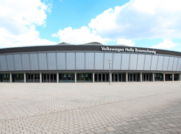 Blick auf die Außenfront einer großen Veranstaltungshalle mit heruntergelassenen Außenjalousien im Obergeschoß